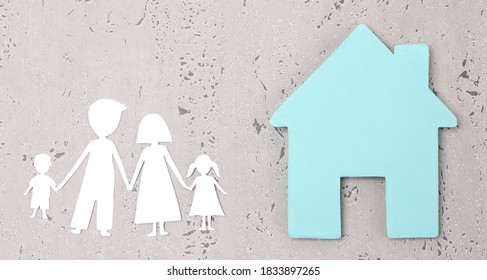 Paper Family Cutout And Paper  Home On Gray Background In Studio.