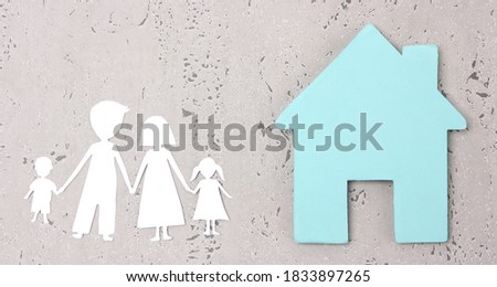 paper family cutout and paper  home on gray background in studio.