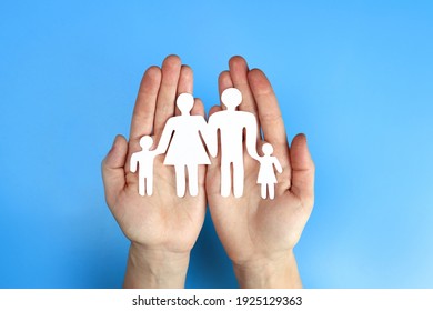 Paper Family In Hand On A Blue Background