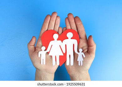 Paper Family In Hand On A Blue Background