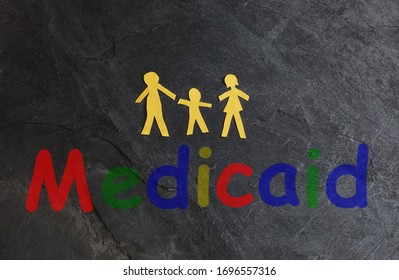 Paper Family Of Three With Colorful Medicaid Text On Textured Surface                              