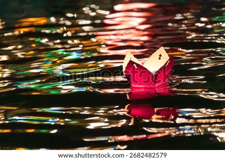 Paper flower lanterns floating through the Thu Bon River in the Hoi An ancient town.Tradition says, that wishes come true, if you let the lanterns swim.