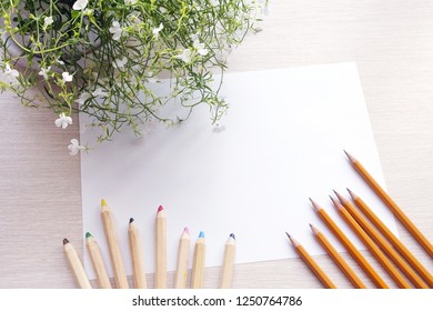 Paper, Flower And Pencils On Wooden Table