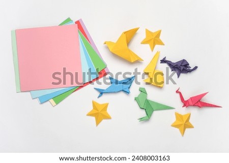 Paper folded origami animal figurines on a white background. Hobbies, creativity