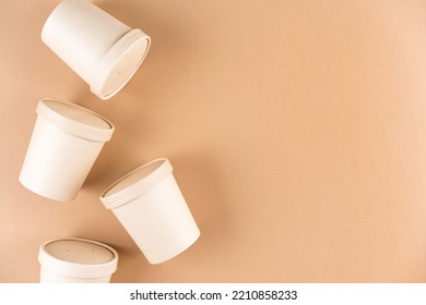 Paper Food Containers For Soup Or Hot Beverages And Food Take Away, Cups With Paper Cap Over Light Brown Background With Copy Space, Mockup Image. Sustainable Food Packaging Concept