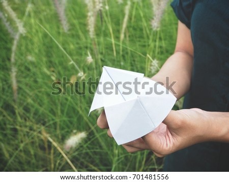 Paper fortune teller on hands with grass flowers