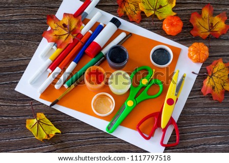 Paper, glue, autumn leaves on a wooden table. Greeting card Halloween spider and cobweb, stamp palm. Children's art project, craft for children. Craft for kids.