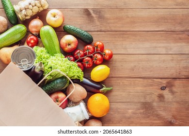 Paper grocery bag with fresh vegetables, fruits, milk and canned goods on wooden backdrop. Food delivery, shopping, donation concept. Healthy food background. Flat lay, copy space. - Shutterstock ID 2065641863
