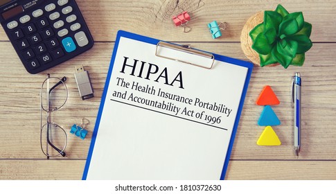 Paper with HIPAA The Health Insurance Portability and Accountability Act of 1996 on the table, calculator and glasses