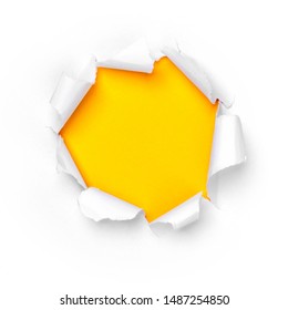 Paper hole in white paper with ragged edges with yellow background.