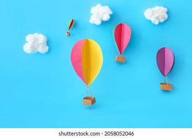 Paper hot air balloons on color background