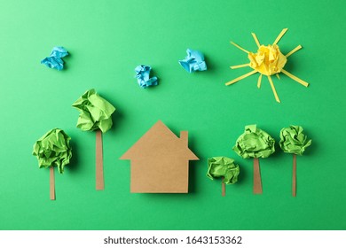 Paper House, Clouds, Sun And Trees On Green Background, Top View