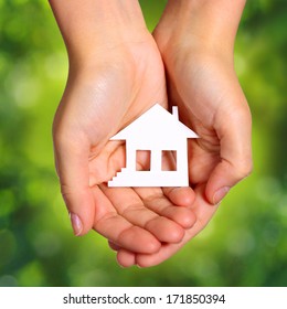 Paper House in Female Hands over Nature Green Sunny Background. Concept - Shutterstock ID 171850394