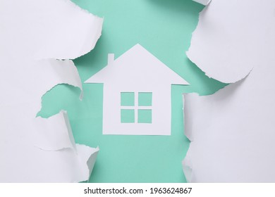 Paper House On Blue Background With White Torn Paper. Concept Art. Minimalism. Top View