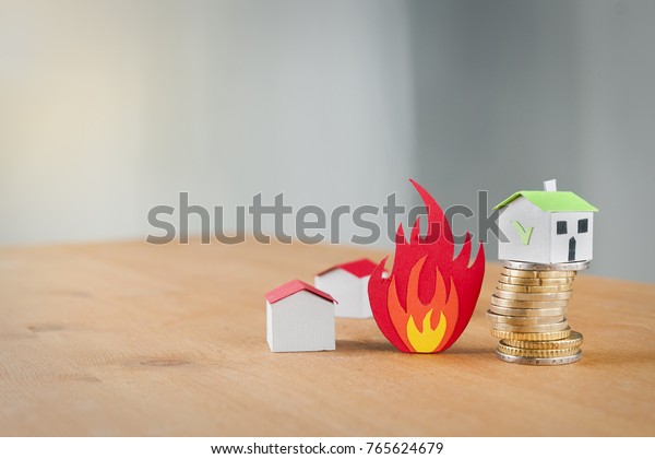Paper houses that burns and a safe house over a\
coin pile: fire insurance\
concept
