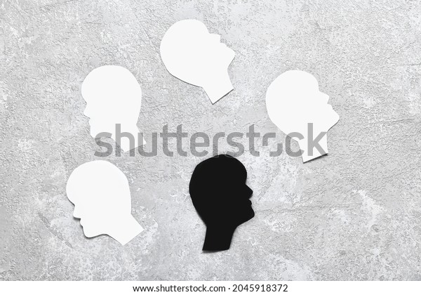 Paper\
human heads on light background. Concept of\
racism