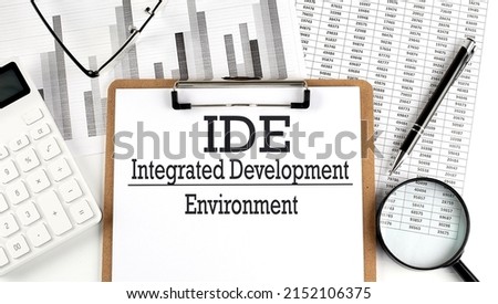 Paper with IDE INTEGRATED DEVELOPMENT ENVIRONMENT table on charts, business concept