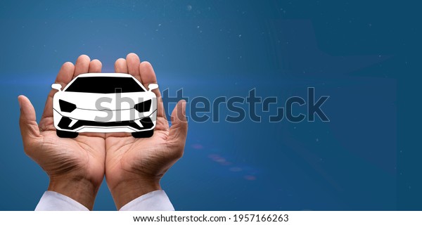 Paper image of car\
in cupped hands on blue background, for Financial, Security and Car\
insurance concept. 
