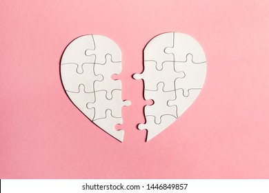 Paper Jigsaw Puzzle Heart Split In Two Pieces Isolated On Pink Background, Top View, Flat Lay, Divorce, Depression And Breakup Concept, Crying, Medical Cardiovascular Health Care Problems