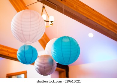 Paper lanterns hung from the ceiling at a wedding reception indoors. - Powered by Shutterstock