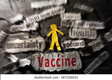 Paper Man Surrounded By Coronavirus And Economy Related New Headlines With Vaccine Text In Red                               