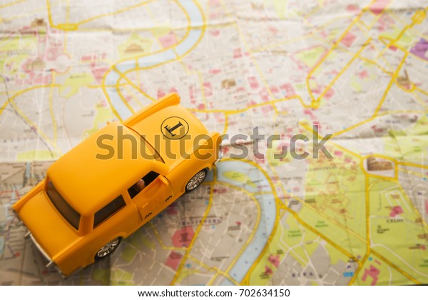 paper map and yellow taxi\
car - travel service and business background. auto stand on paper\
urban card