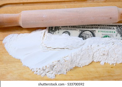 Paper Money Dollars And Wheat Flour On A Wooden Board With A Rolling Pin