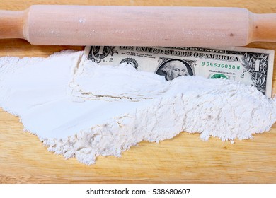 Paper Money Dollars And Wheat Flour On A Wooden Board With A Rolling Pin