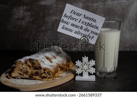 Paper note with message DEAR SANTA BEFORE I EXPLAIN HOW MUCH DO YOU KNOW ALREADY joke humor pun.Homemade Christmas traditional cake pie with marzipan nuts and dried fruits pastry dessert stollen with
