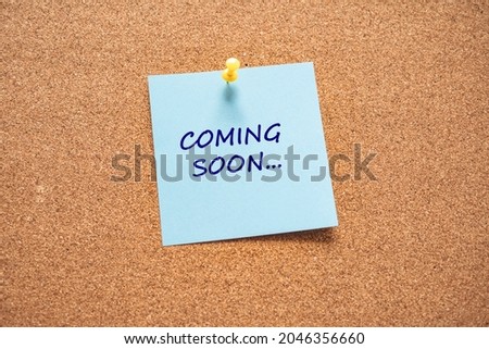 Paper note on cork board written with COMING SOON inscription. Business and education concept. COMING SOON text written on sticky note.