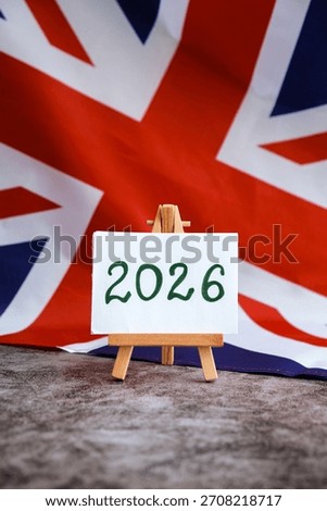 Paper note with text 2026 on National symbol of Great Britain. British wave the UK silky flag background. Financial outlook planning, new year annual report