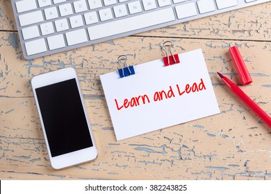 Paper note with text Learn and Lead