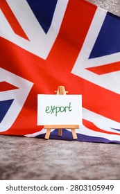 Paper note with words EXPORT on National symbol of Great Britain. British wave the UK silky flag background. Concept of economy industry global market international shipping