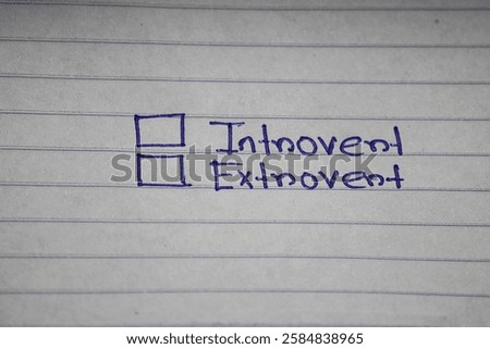 Paper notebook lined sheet , with two choices checklists to choose between INTROVERT and EXTROVERT. Concept of personality type