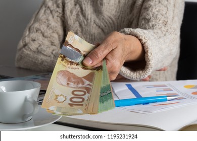 Paper Notes From Canada. Dollar. Canadian Cash. Person Giving Papernotes On Desk.