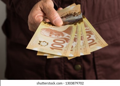 Paper Notes From Canada. Dollar. Canadian Cash. Front View Of Old Woman's Hand Handling Bills.