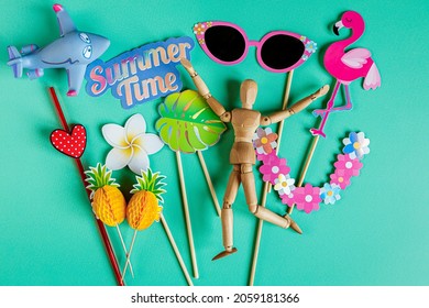 paper party accessories and wooden mannequin having fun on summer vacation