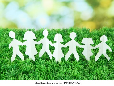 Paper people on green grass on bright background - Powered by Shutterstock
