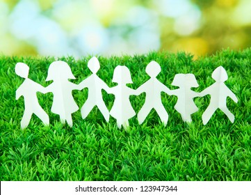 Paper People On Green Grass On Bright Background