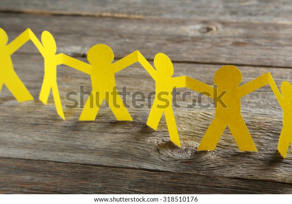 Paper people on the grey wooden background