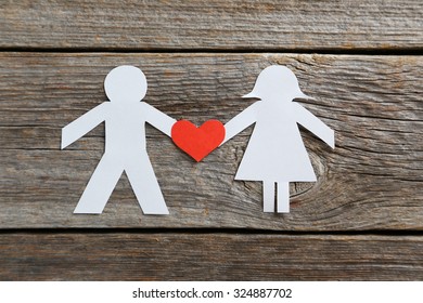 Paper people together in love on the grey wooden background - Powered by Shutterstock