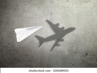 Paper Plane In Mid Flight With Shadow Of A Real Plane