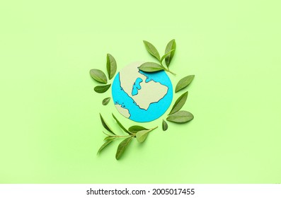 Paper Planet Earth With Green Leaves On Color Background. Ecology Concept