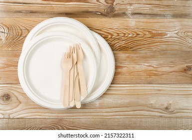 Paper plate, fork, knife on wood table. Eco tableware, disposable cutlery, biodegradable, eco bio table setting for picnic, recycle reusable utensil on white background top view with copy space - Shutterstock ID 2157322311