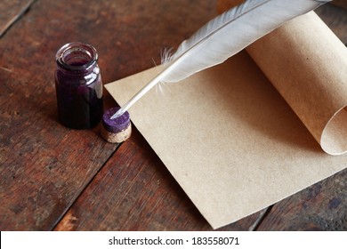 Paper and quill pen on nice old wooden background