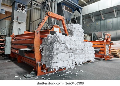 A paper recycling factory plant shredding machine, shredding waste paper into square bails, ready to be pulped and reused. Recycle waste materials to offset pollution and save the planet. - Shutterstock ID 1663436308