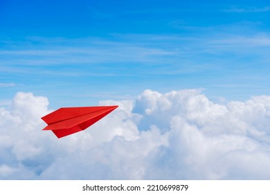 Paper red planes in blue sky. Sky background. The atmosphere is on the plane, sky is full of clouds floating around, both small and large. The atmosphere is on the plane.
