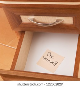 paper reminder of the necessary be yourself in open desk drawer