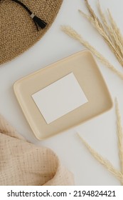 Paper Sheet Card With Mockup Copy Space. Straw Hat, Muslin Blanket, Pampas Grass Stems, Neutral Beige Plate