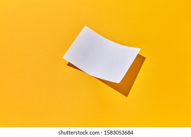 Paper sheet empty for notes or letter for greeting on an yellow background with hard shadows, copy space. Flat lay.